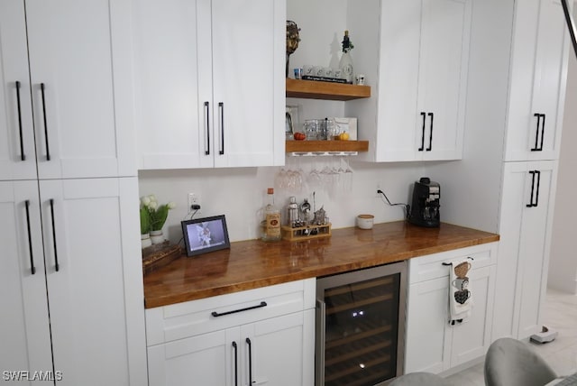 bar with white cabinets, butcher block countertops, and beverage cooler