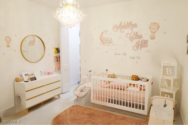 bedroom with a crib and an inviting chandelier