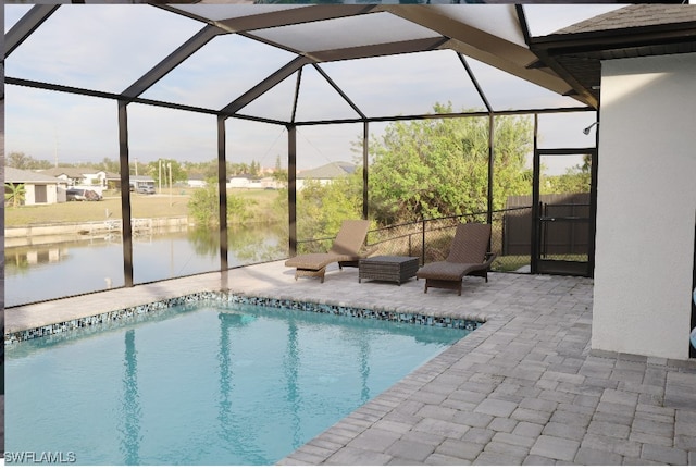 view of pool with a lanai, a patio area, and a water view