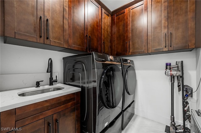 washroom featuring a sink, cabinet space, and separate washer and dryer