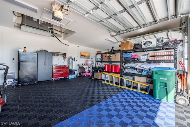 garage featuring a garage door opener and freestanding refrigerator