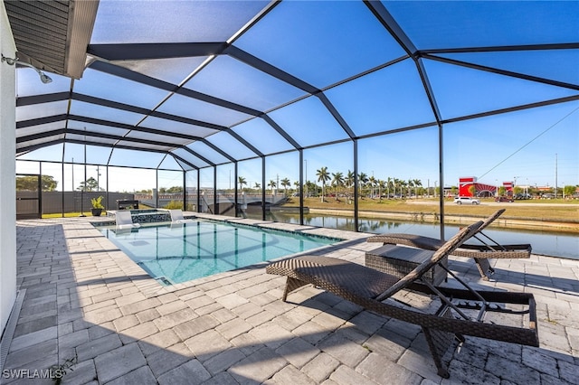 view of pool with glass enclosure, a patio, a water view, and a pool with connected hot tub