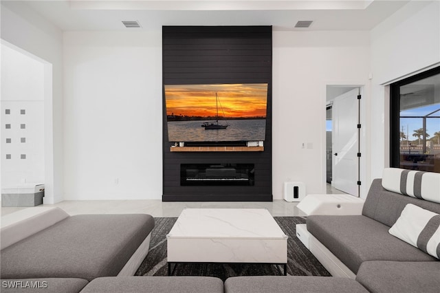 living room featuring visible vents and a large fireplace