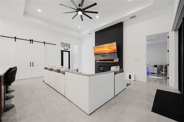 living area featuring visible vents, ceiling fan, a tray ceiling, recessed lighting, and marble finish floor