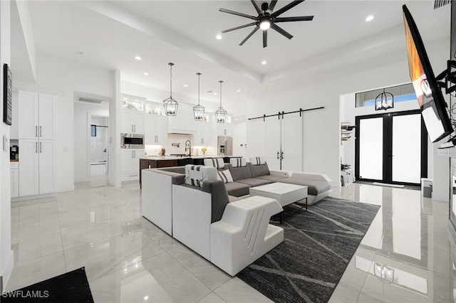 living area featuring recessed lighting, a high ceiling, and a ceiling fan