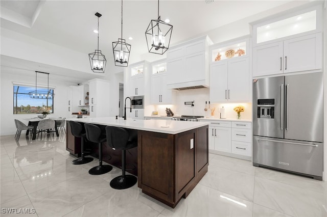 kitchen featuring light countertops, an island with sink, a chandelier, and stainless steel appliances