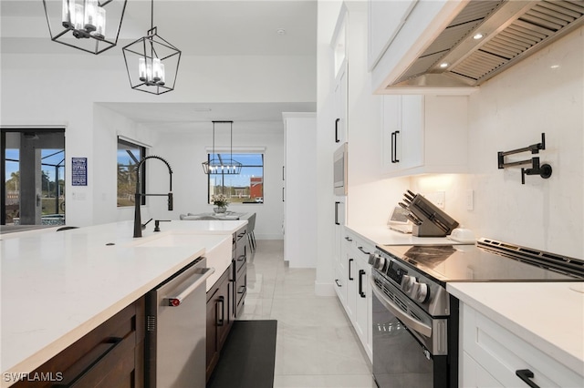 kitchen featuring custom range hood, stainless steel appliances, an inviting chandelier, light countertops, and hanging light fixtures