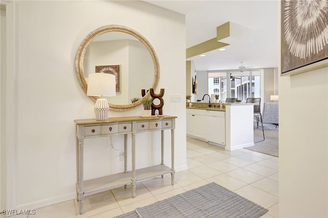 corridor featuring light tile patterned flooring and sink