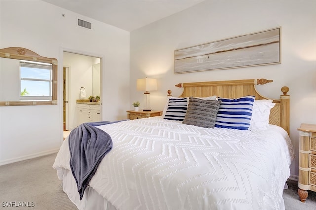 carpeted bedroom featuring ensuite bath