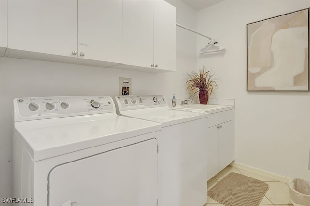 clothes washing area featuring washer and dryer, cabinets, light tile patterned floors, and sink