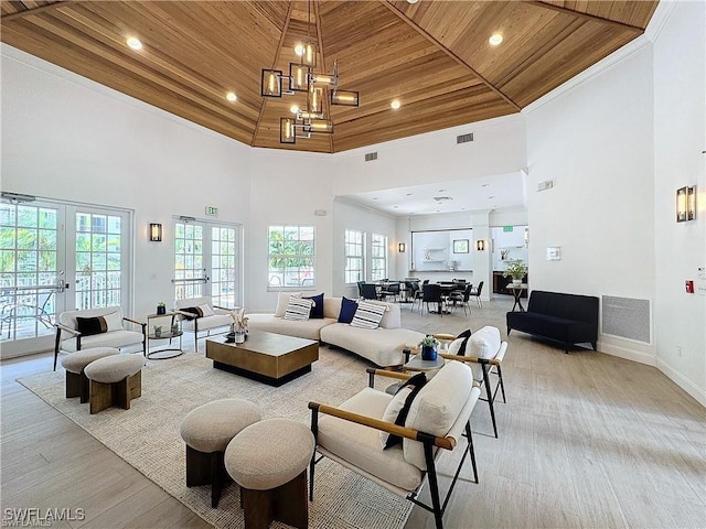 living room featuring light hardwood / wood-style floors, wood ceiling, a high ceiling, and french doors