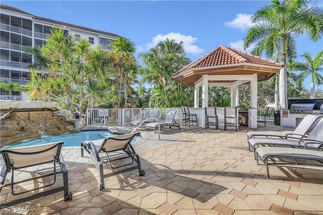 view of patio / terrace with pool water feature, a gazebo, exterior bar, and a community pool