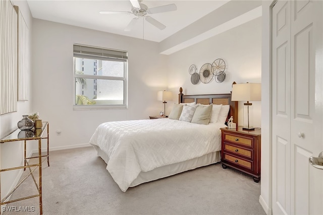 carpeted bedroom featuring ceiling fan and a closet