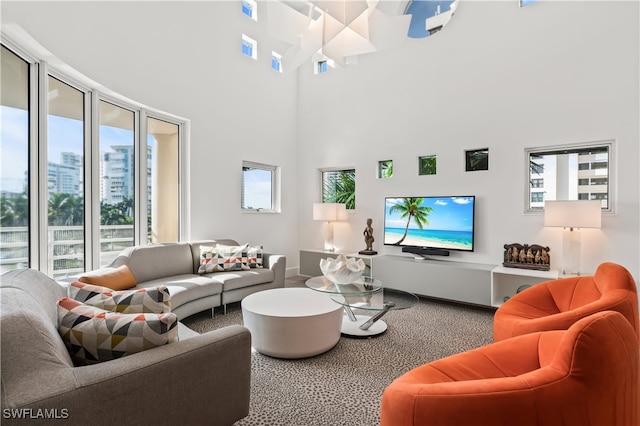 carpeted living room with a high ceiling and plenty of natural light