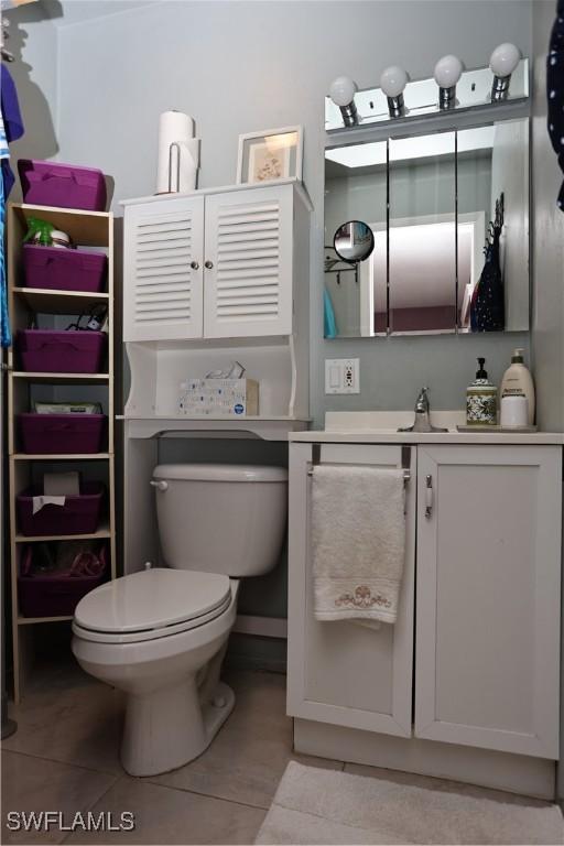 bathroom with tile patterned flooring, vanity, and toilet