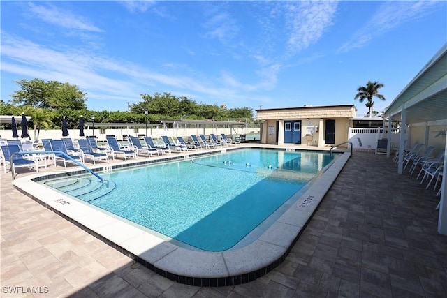 view of swimming pool featuring an outbuilding and a patio