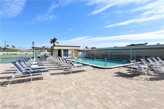 view of swimming pool with a patio area and a water view