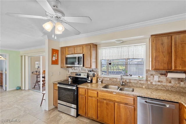 kitchen with tasteful backsplash, sink, ceiling fan, stainless steel appliances, and crown molding