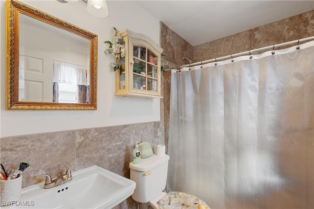 bathroom with tile walls, sink, toilet, and a shower with shower curtain