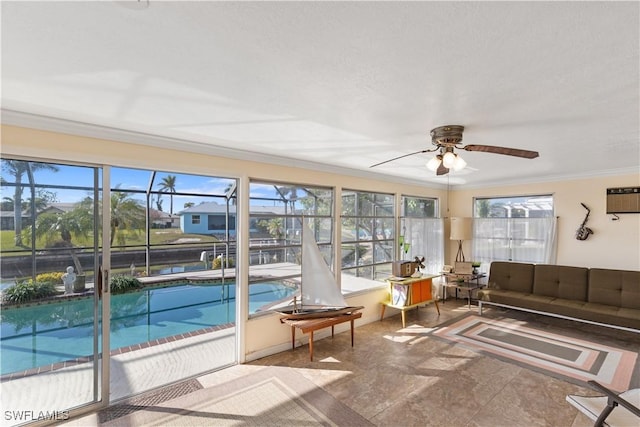 sunroom featuring ceiling fan, plenty of natural light, and a wall mounted AC