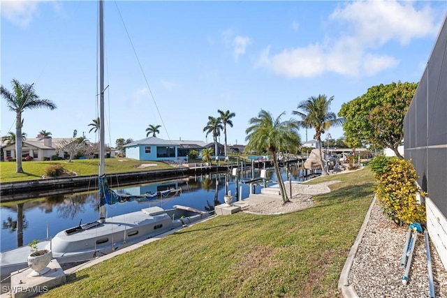 view of dock with a lanai, a water view, and a lawn