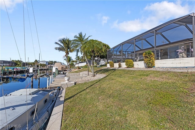 view of dock featuring a water view, glass enclosure, and a lawn