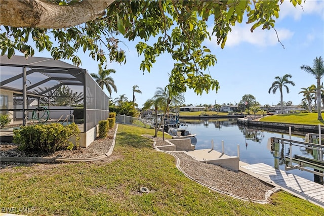 view of dock featuring a water view, a yard, and glass enclosure