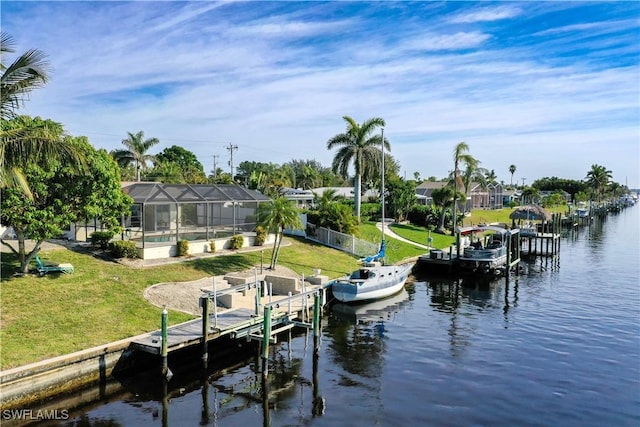 view of dock with a water view, a yard, and glass enclosure