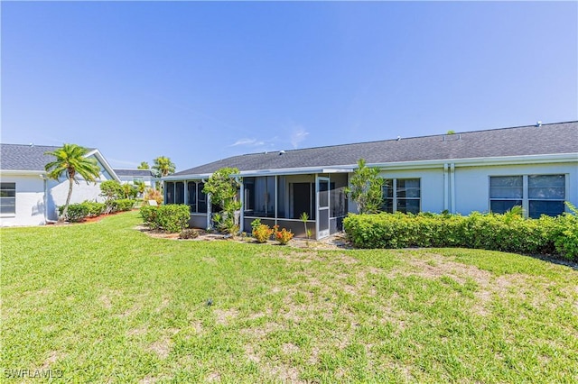 back of property with a sunroom and a yard