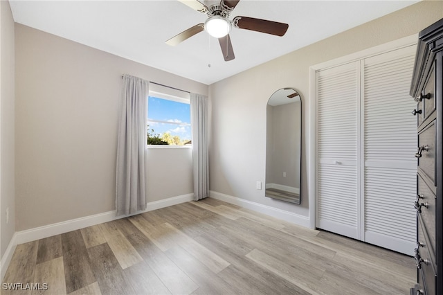 unfurnished bedroom featuring ceiling fan, a closet, and light hardwood / wood-style flooring