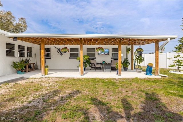 rear view of property featuring a patio area and a lawn