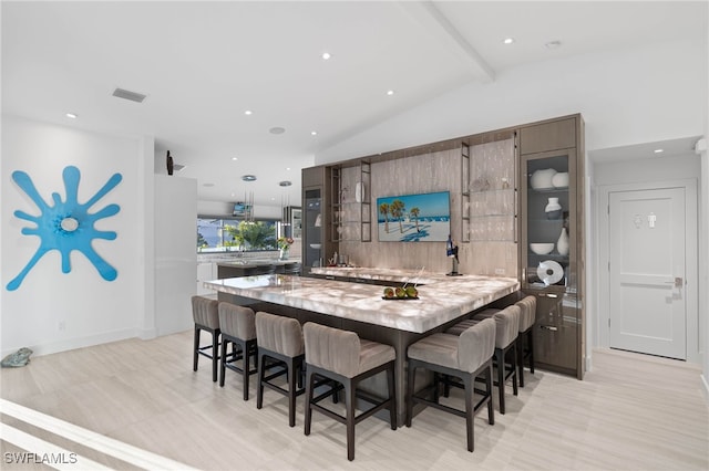 dining room featuring vaulted ceiling with beams