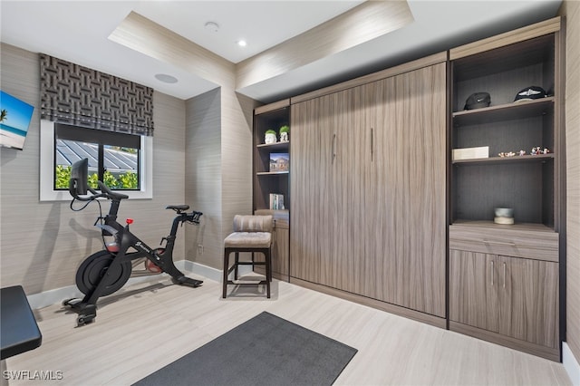 exercise room with light hardwood / wood-style floors