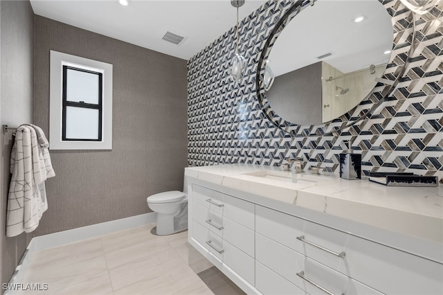 bathroom featuring tile patterned floors, toilet, vanity, and walk in shower