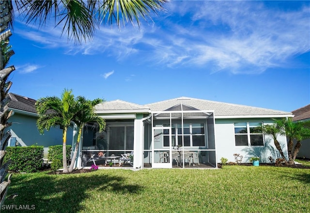 back of property featuring glass enclosure and a yard