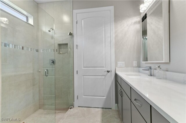 bathroom featuring vanity and a shower with door