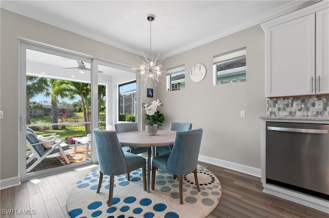 dining area featuring ceiling fan with notable chandelier, dark hardwood / wood-style floors, and crown molding