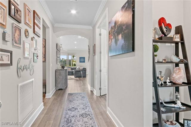 corridor featuring light wood-type flooring and ornamental molding