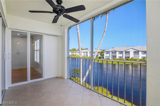 unfurnished sunroom with ceiling fan and a water view