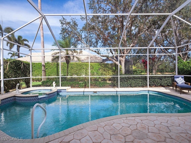 view of pool with a lanai and an in ground hot tub