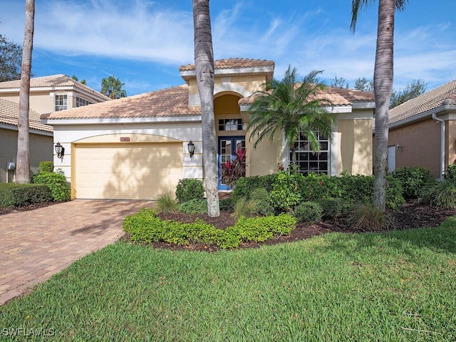 mediterranean / spanish-style house with a garage and a front lawn