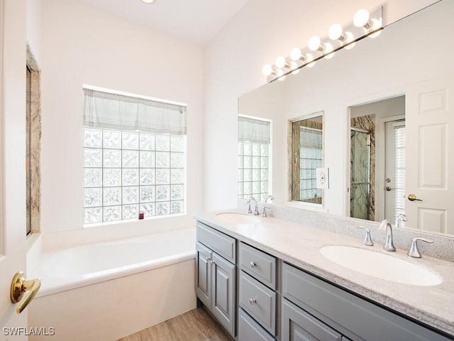 bathroom with vanity, wood-type flooring, and shower with separate bathtub