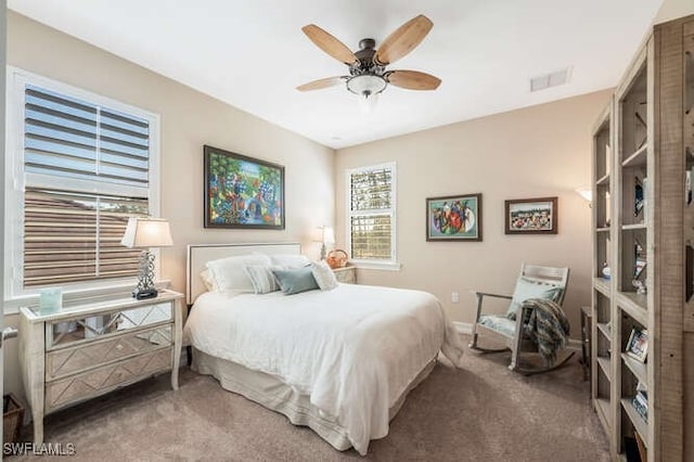 carpeted bedroom featuring ceiling fan and visible vents