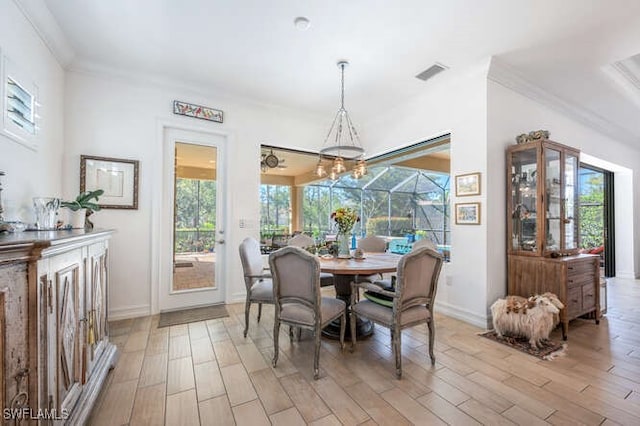dining room featuring light wood-type flooring, visible vents, and crown molding