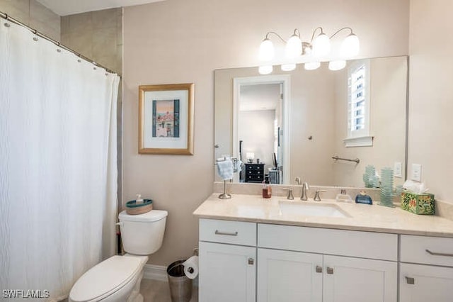 bathroom featuring curtained shower, vanity, and toilet