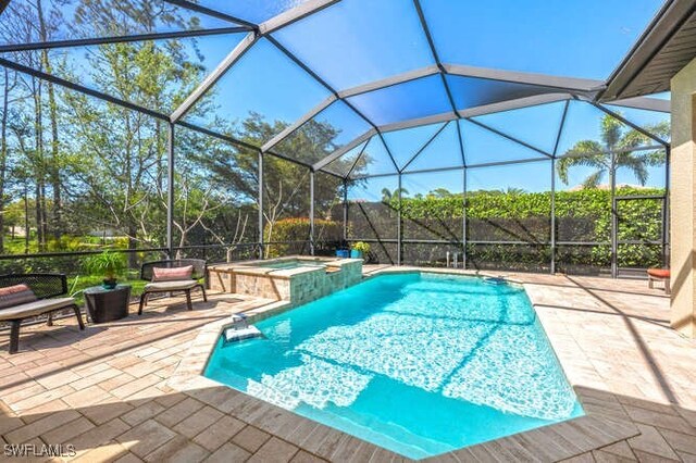 view of swimming pool featuring a pool with connected hot tub, a lanai, and a patio