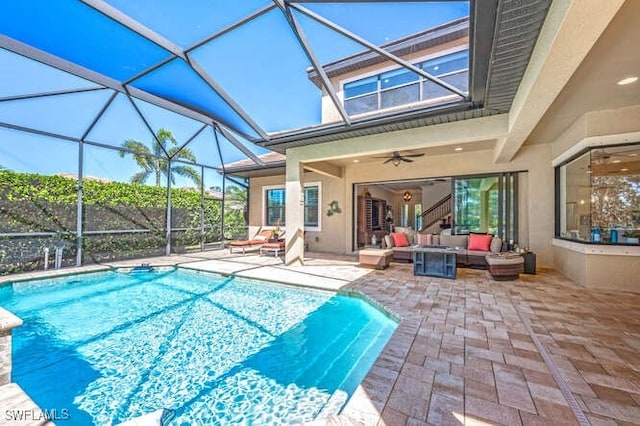 pool with a patio area, ceiling fan, glass enclosure, and an outdoor living space