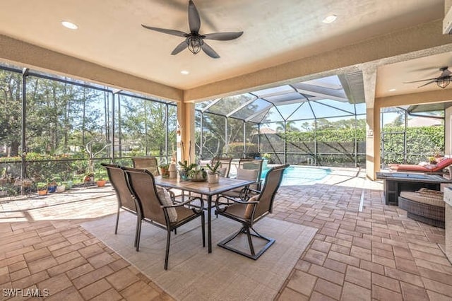 view of patio featuring a lanai, an outdoor pool, and a ceiling fan