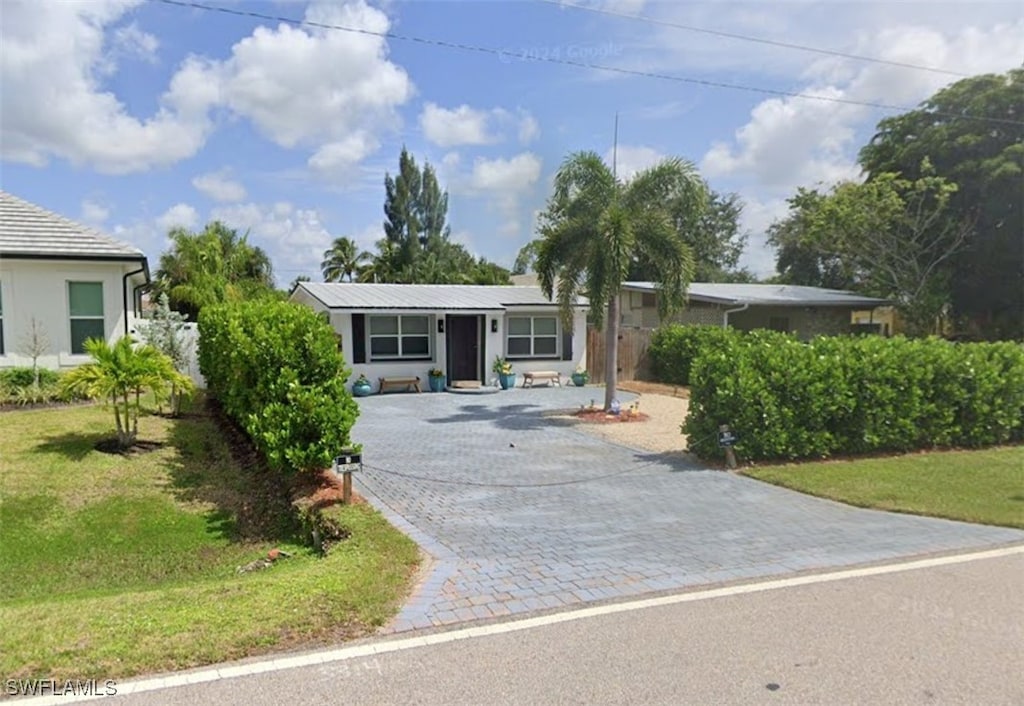 single story home featuring a front lawn