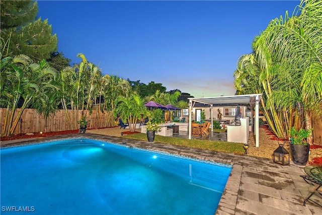 pool at dusk featuring a patio area